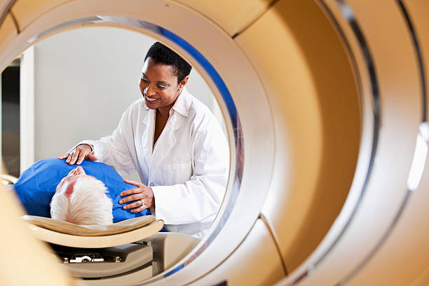View of radiologist or technician with a patient through an integrated PET-CT scanner.